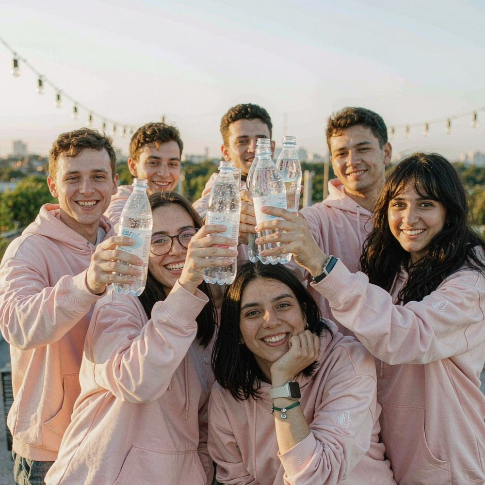 Company team in matching custom printed hoodies, toasting at a rooftop party