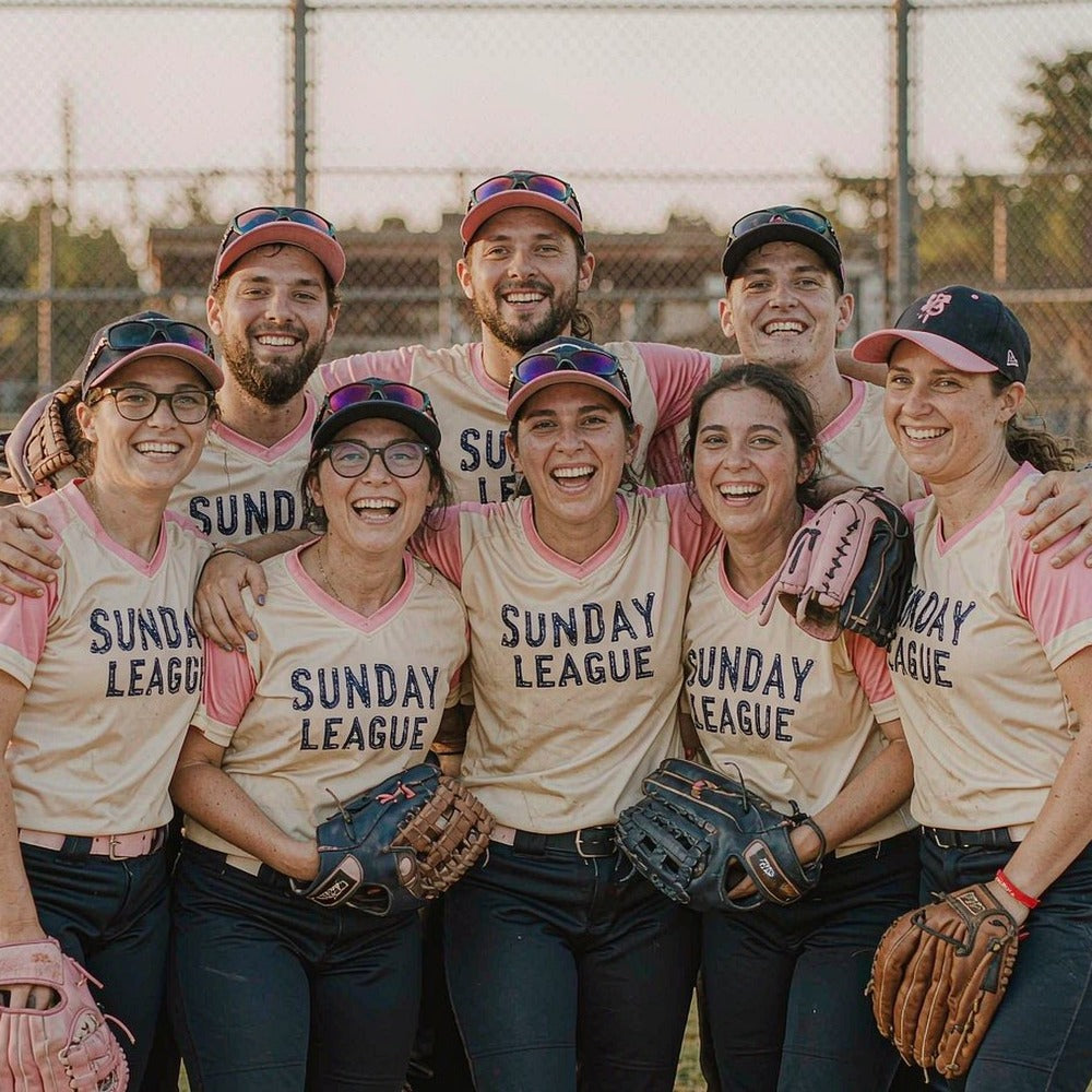 Softball team in matching SUNDAY LEAGUE custom printed tees and caps on the bench